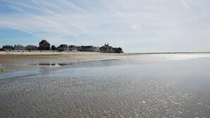 A beach with a large building in the background. - Beautiful 4* villa on the sand, feet in the water, stunning bay views (Le Crotoy)