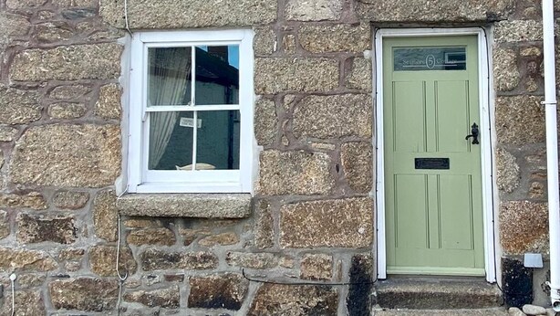A stone building with two windows and a green door. - Cosy Character Cottage With Sea View In Mousehole (Mousehole, Penzance)