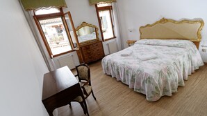 Une chambre à coucher avec un lit en bois, un bureau, une chaise et une commode.