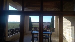 Quarto com varanda com vista para um campo e um edifício.