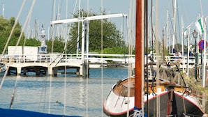 En lysthavn med flere både i havnen, en gangbro og en klar himmel.