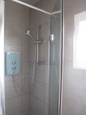 A glass-enclosed shower with a control panel and a handheld showerhead. - An Idyllic cottage in St.Monans with sea views. (St Monans)