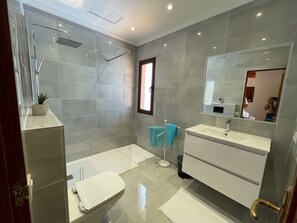 Regadera, secadora de cabello, toallas, papel de baño 