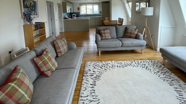 A spacious living area with a grey sofa set, a large rug, and a dining table. - Unique property, in a peaceful and serene location,  within easy reach of all amenities. (Humbie)