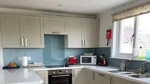 A modern kitchen with white cabinets, a built-in oven, a microwave, and a red toaster. - Unique property, in a peaceful and serene location,  within easy reach of all amenities. (Humbie)