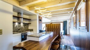 Een moderne keuken met een centraal eiland, een ingebouwde oven en een roestvrijstalen afzuigkap.