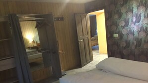 Un dormitorio con cama, armario y espejo.