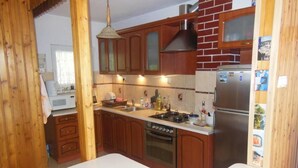 Una cocina con armarios de madera, un refrigerador de acero inoxidable, una estufa y un lavavajillas.