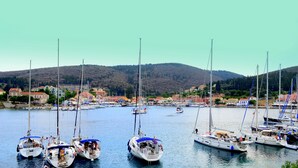 A marina with several sailboats docked, surrounded by buildings and hills in the background. - Villa With Private Pool (Magganos)