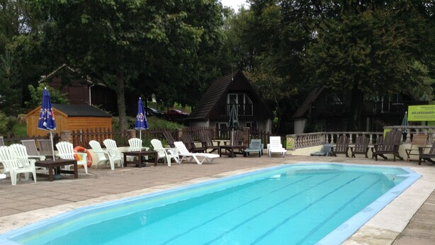 A rectangular swimming pool with clear blue water, surrounded by lounge chairs and umbrellas. - Spacious property in rural setting
Free Wifi (callington)