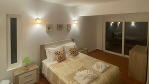 A bedroom with a bed, bedside tables, wall-mounted lights, a window, and a view of the outside. - 2-bed Villa with Private Pool and Panoramic Views in a quiet residential area (Lagos)