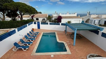 Een buitenzwembad en ligstoelen