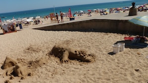 A sandy beach with a large sand sculpture of a dinosaur and a small hole with a colorful object inside. - 2-bed Villa with Private Pool and Panoramic Views in a quiet residential area (Lagos)
