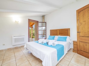 Une chambre d’hôtel avec un lit, une armoire en bois, une fenêtre donnant sur un paysage agréable et un appareil de climatisation.