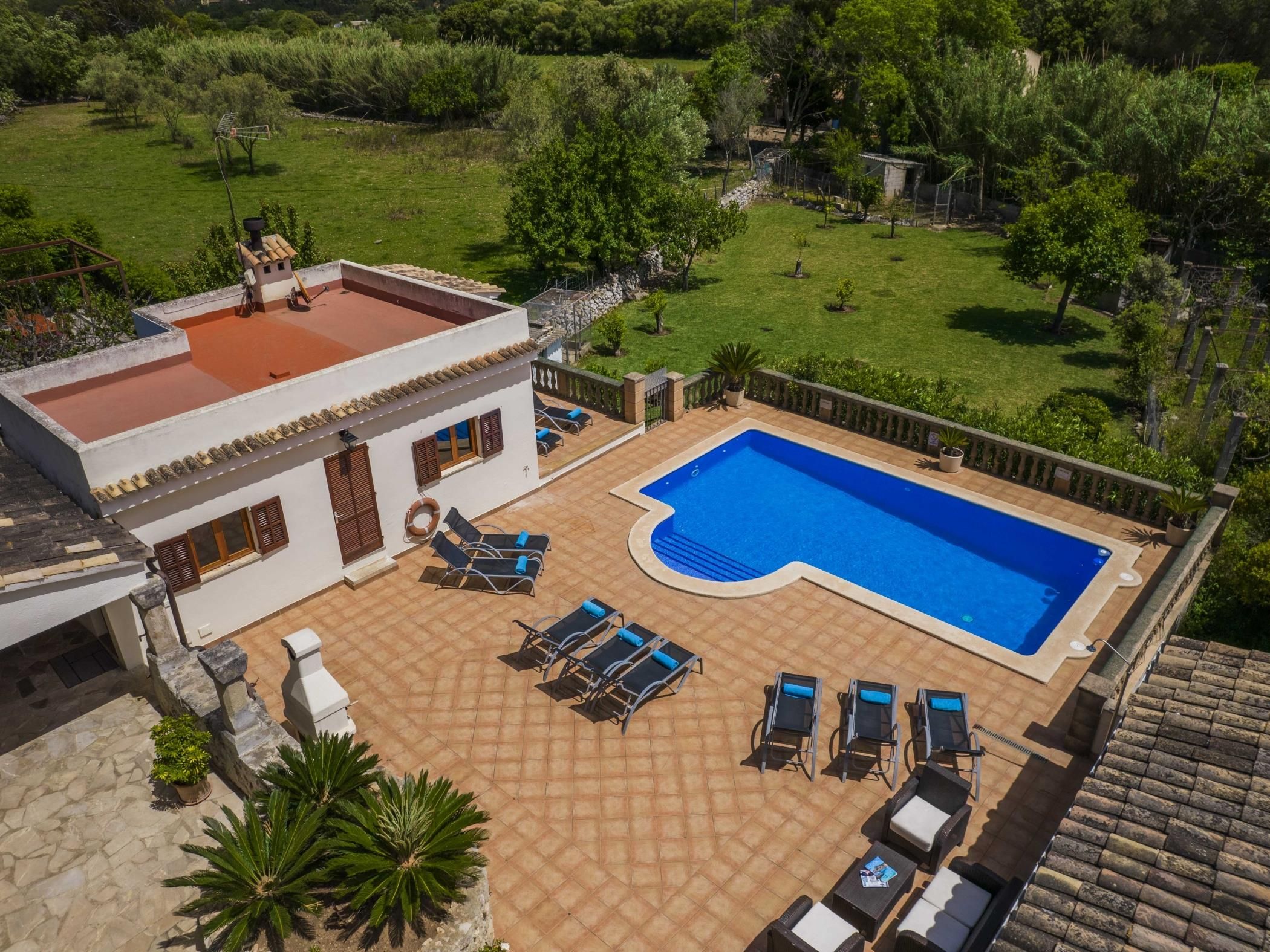 A residential property with a swimming pool, outdoor seating, and a garden.