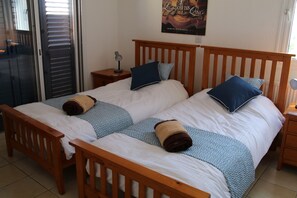 Ein Doppelbett mit Holz-Kopfteil, zwei Nachttische und ein Poster an der Wand.