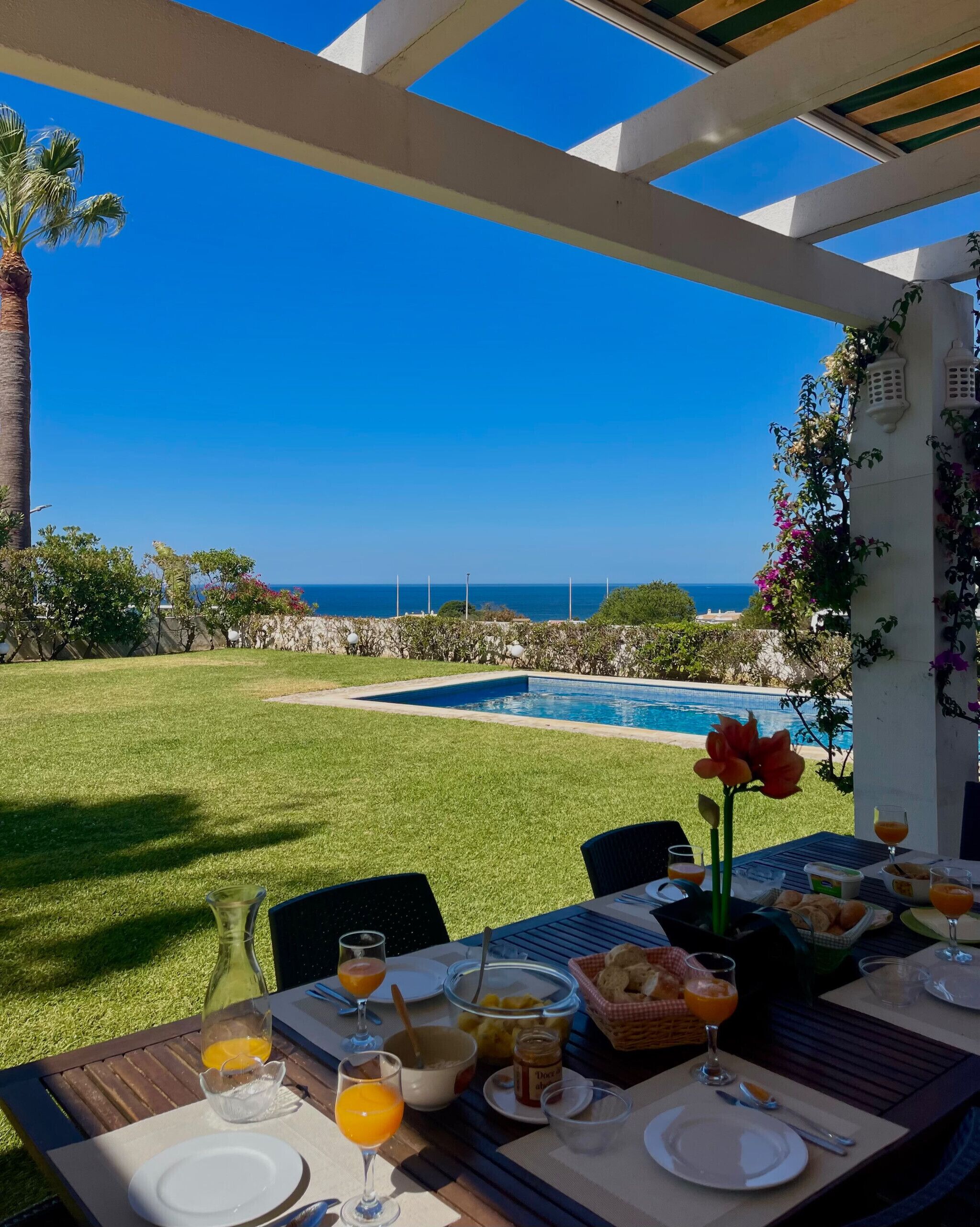 An outdoor dining area with a view of the ocean and a pool.