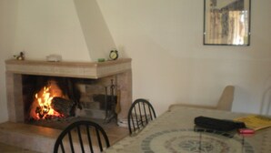 Ein Essbereich mit Kamin, gefliestem Boden und einem gerahmten Bild an der Wand.