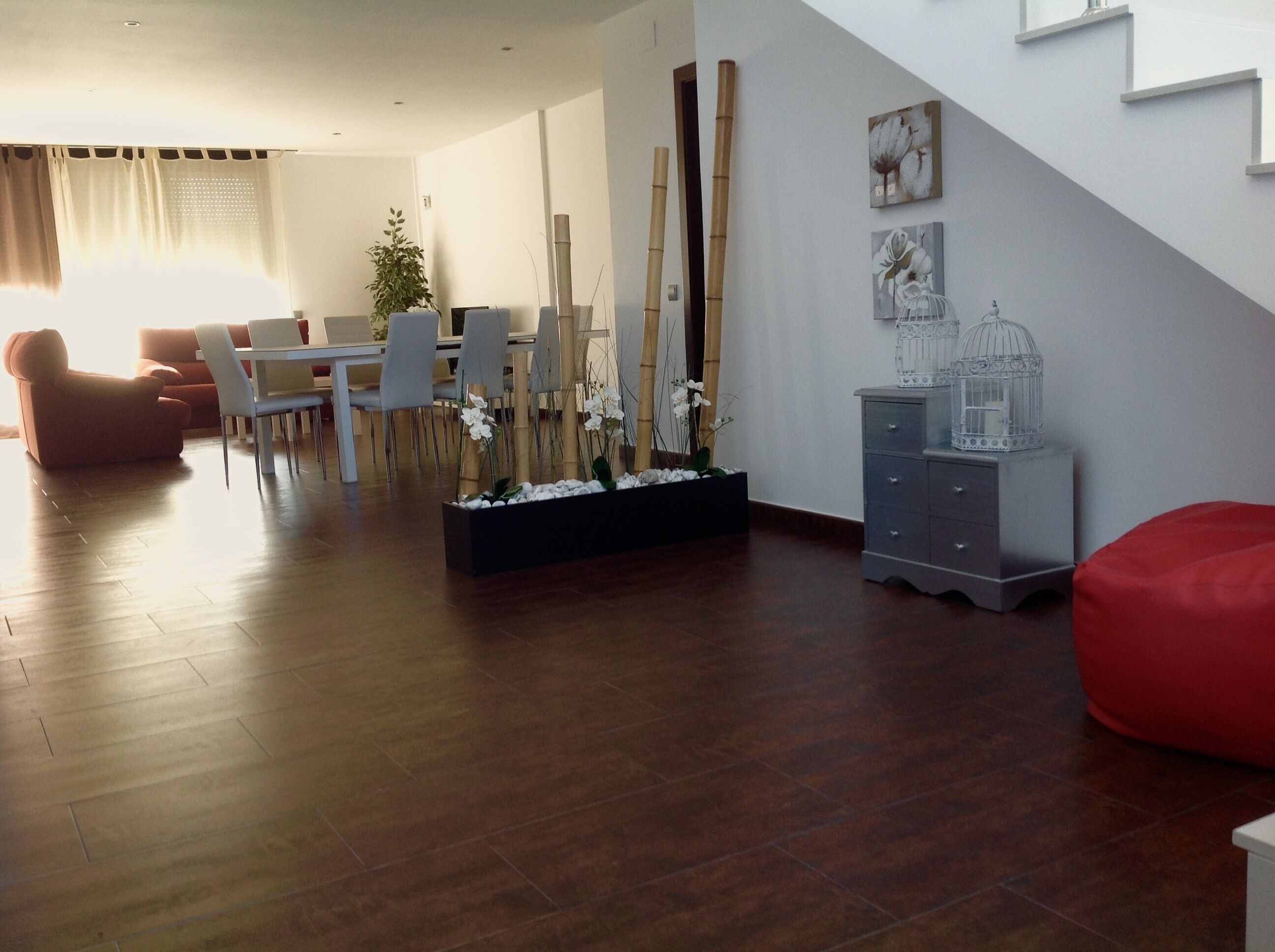 Un salon moderne avec un coin repas, un plancher en bois et un escalier.