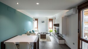 A modern kitchen with a dining area, a sofa, and a TV. - Apartment in Yeste (2 places) (Yeste)