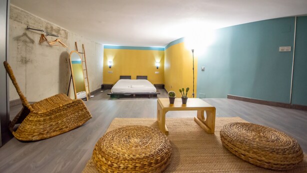 A room with a bed, a mirror, a wooden table, and wicker furniture. - Apartment in Yeste (2 places) (Yeste)