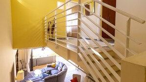 A multi-level interior with a staircase, a living area with a sofa and a small table, and a view of the upper floor. - Villa Callista -  Modern Villa that sleeps 8 guests  in 4 bedrooms (Paphos)