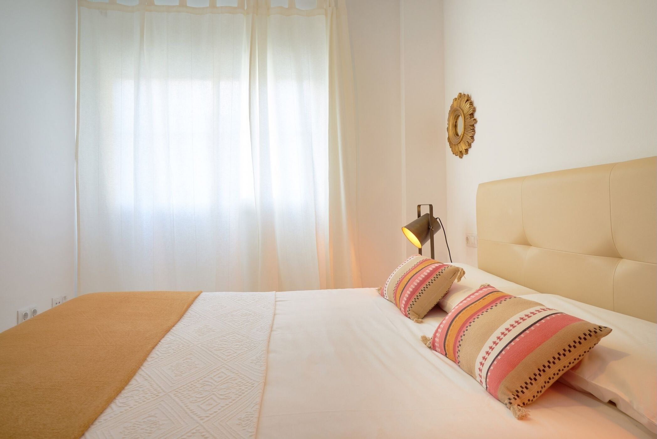 Un dormitorio con una cama, una lámpara y un adorno en la pared.