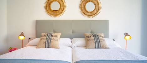 A double bed with two pillows, a headboard, and two wall-mounted circular decorations.