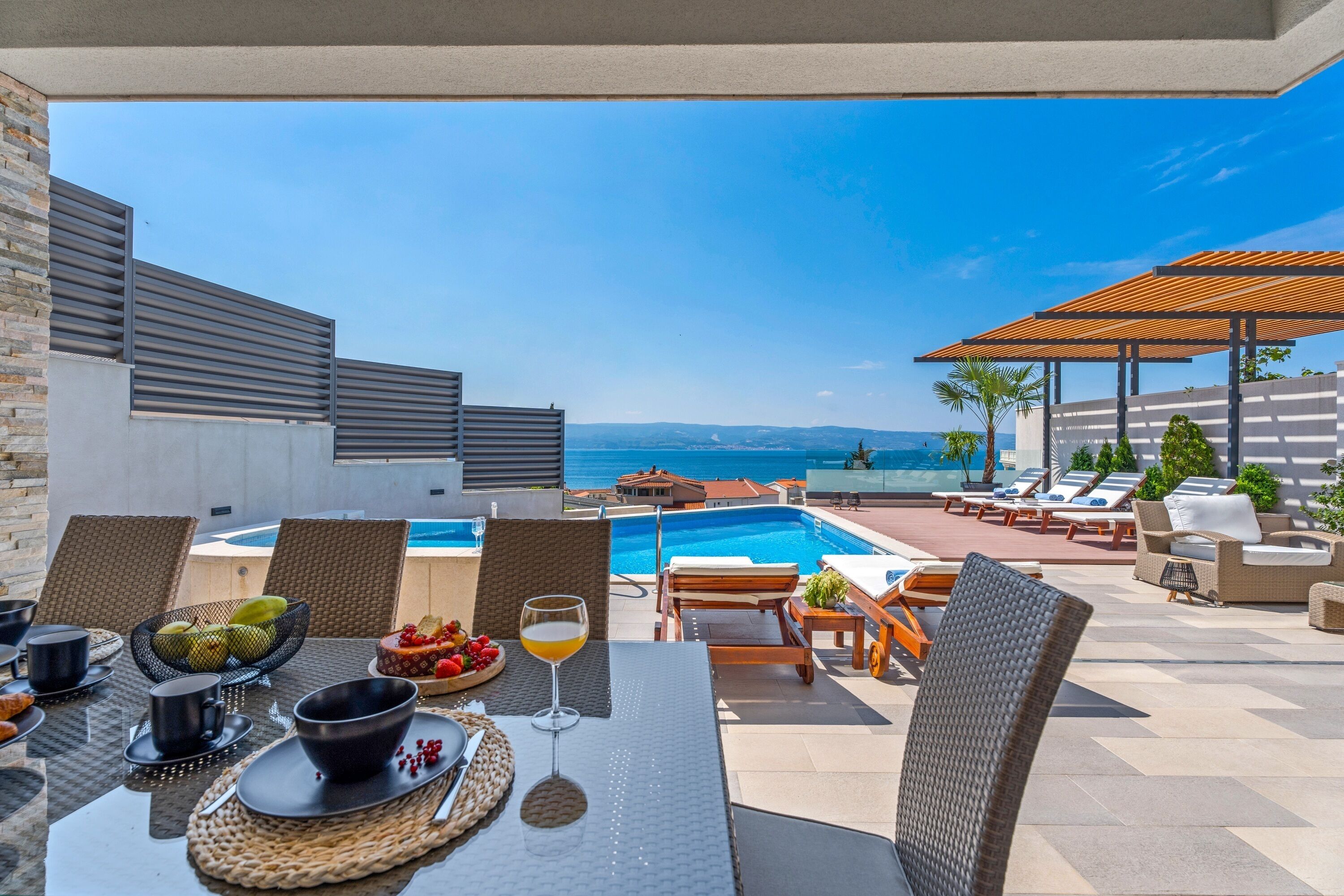 Eine Dachterrasse mit Pool, Essbereich und Lounge-Bereich.