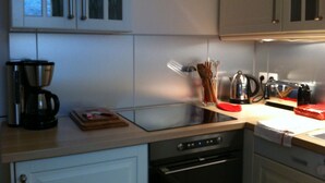 Eine Küche mit weißen Schränken, einer Kaffeemaschine, einem Toaster und einem Geschirrspüler.