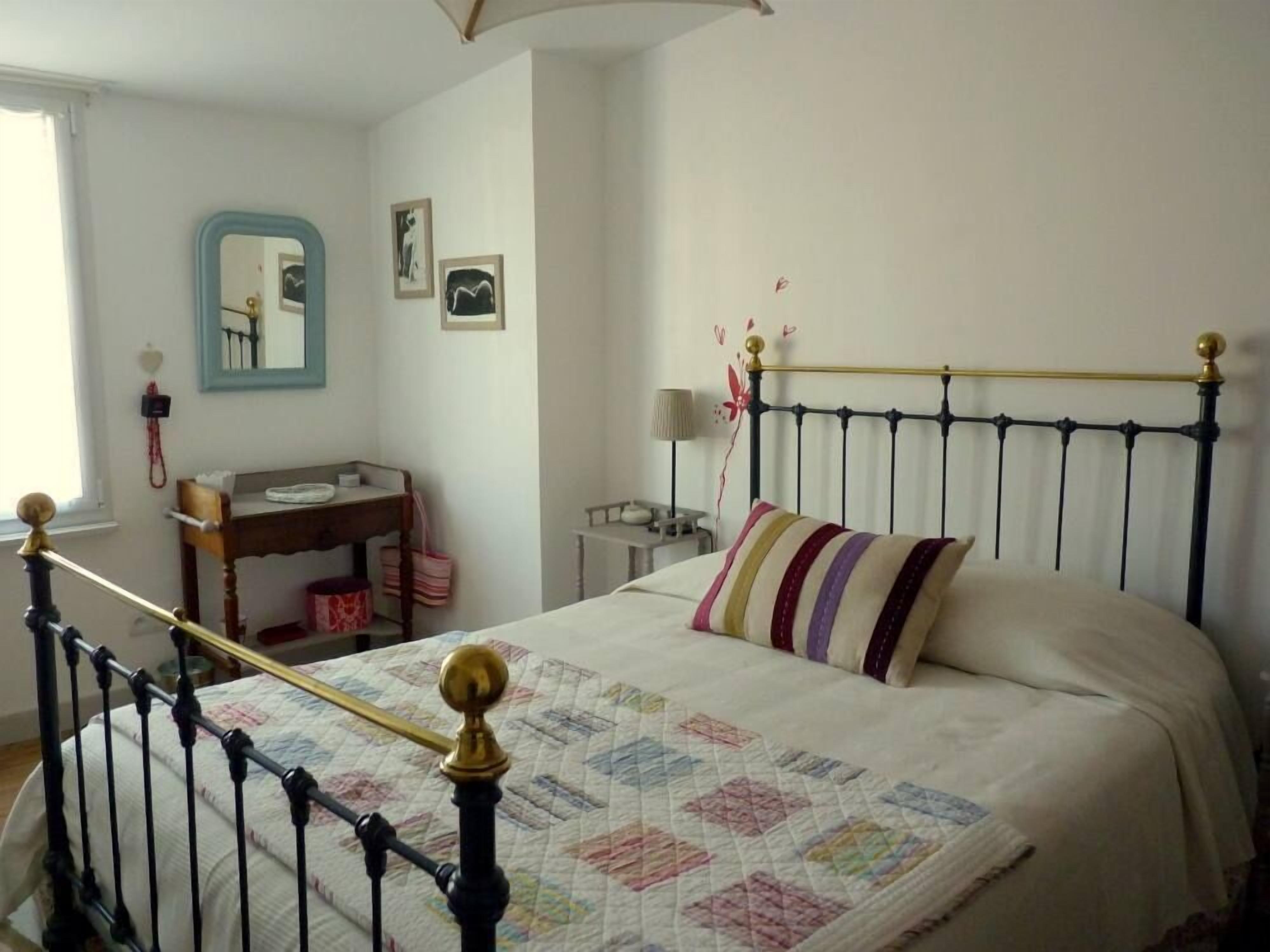 A bedroom with a bed, a desk, and a chair.