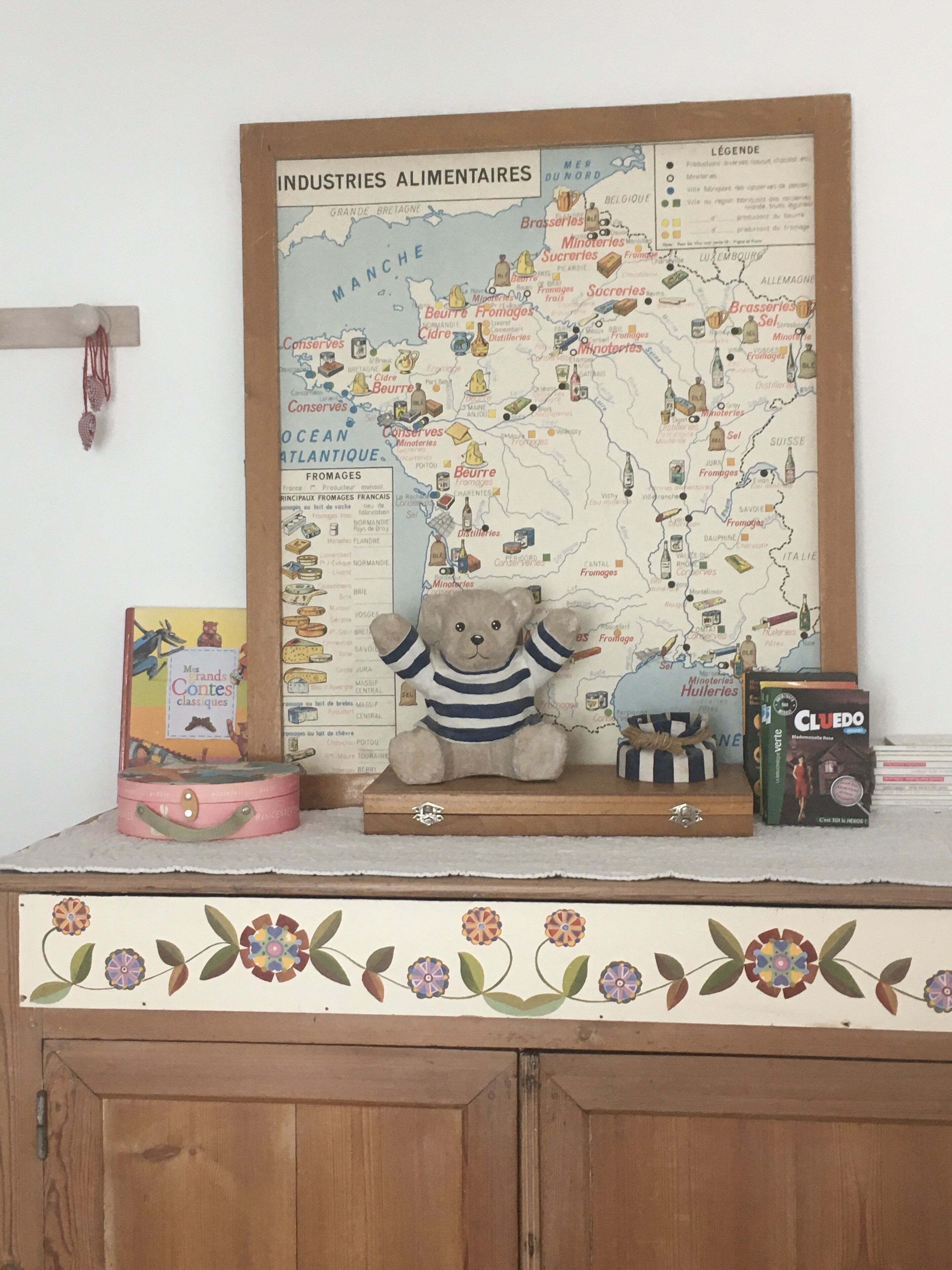 A map titled 'INDUSTRIES ALIMENTAIRES' with illustrations of food products and beverages, placed on a shelf with a decorative border.
