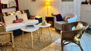 A cozy living room with a sofa, armchairs, a coffee table, and a bookshelf.