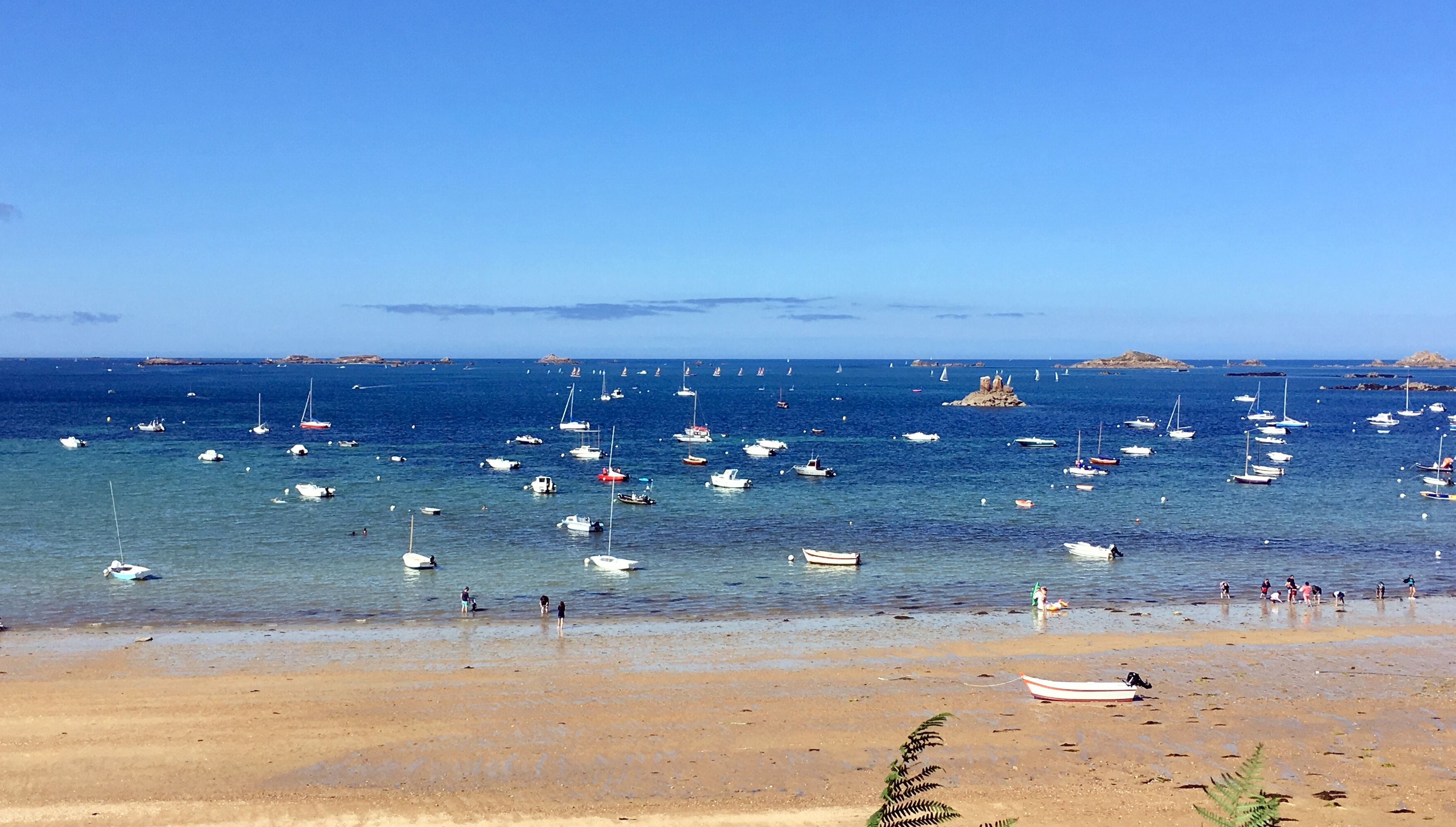 Uma praia com barcos e pessoas.