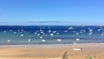 Una playa con barcos y gente.