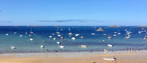 Uma praia com barcos e pessoas.