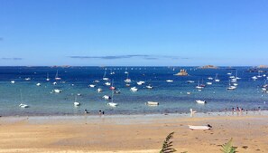 Una playa con barcos y gente.
