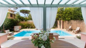 An outdoor pool area with a pergola, white curtains, and lounge chairs. - Villa Il Rifugio, villa with private pool (Pietrasanta)