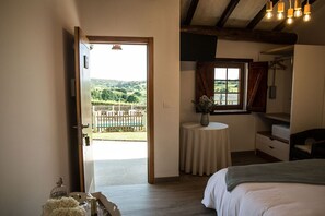 A bedroom with a bed, a bedside table with a vase, a window with curtains, and a view of a fenced outdoor area. - RURAL HOUSE WITH SWIMMING POOL AND CLOSE TO THE BEACH (Cances Grande)