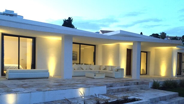 A modern house with a spacious outdoor area featuring a white sofa and a dining table. - 4 Beds & 4 Bath, 150mts from the beach, Private Heated Pool, BBQ (Fuengirola)