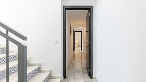 A hallway with a staircase on the left and a door leading to another room on the right. - Luxury villa with Private Pool Benalmadena (Benalmádena)