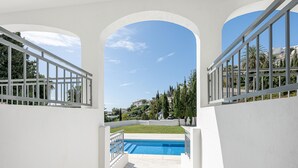 A swimming pool with a view of a green lawn and trees, framed by white walls and arches. - Luxury villa with Private Pool Benalmadena (Benalmádena)