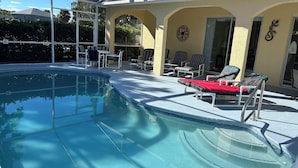 A pool area with lounge chairs and a covered patio. - Executive Villa with lake views,  south facing pool 4 bed 3 bath. Games room (Davenport)