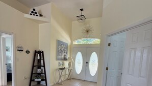 A spacious hallway with beige walls, a white door, and a decorative ceiling light. - Executive Villa with lake views,  south facing pool 4 bed 3 bath. Games room (Davenport)