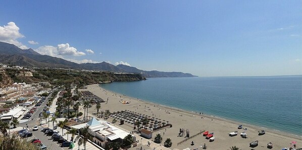 Enjoy the serene coastal views and relax on the beach with umbrellas and sun loungers.