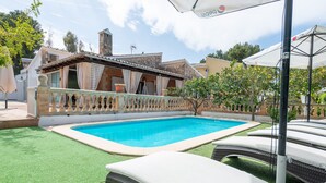 A swimming pool with a tiled deck, surrounded by a low fence and a small tree. - Family villa with private pool, 500 m from the beach (Alcúdia)