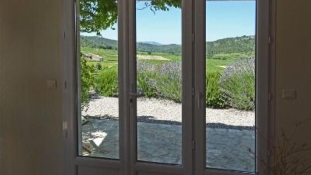 A room with a large glass door leading to an outdoor view of a green landscape with hills and lavender fields. - House / Villa - Coustouge (Coustouge)