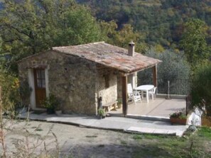 A rustic stone house with a small patio and outdoor seating. - Detached house with garden (Coaraze)