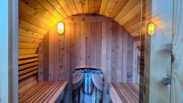 A wooden sauna with benches and a central heating element. - WesterOurthe 6 persons with sauna (Durbuy)
