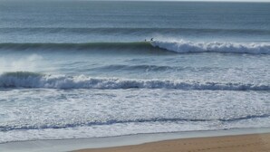 Una playa con olas y cielo despejado.